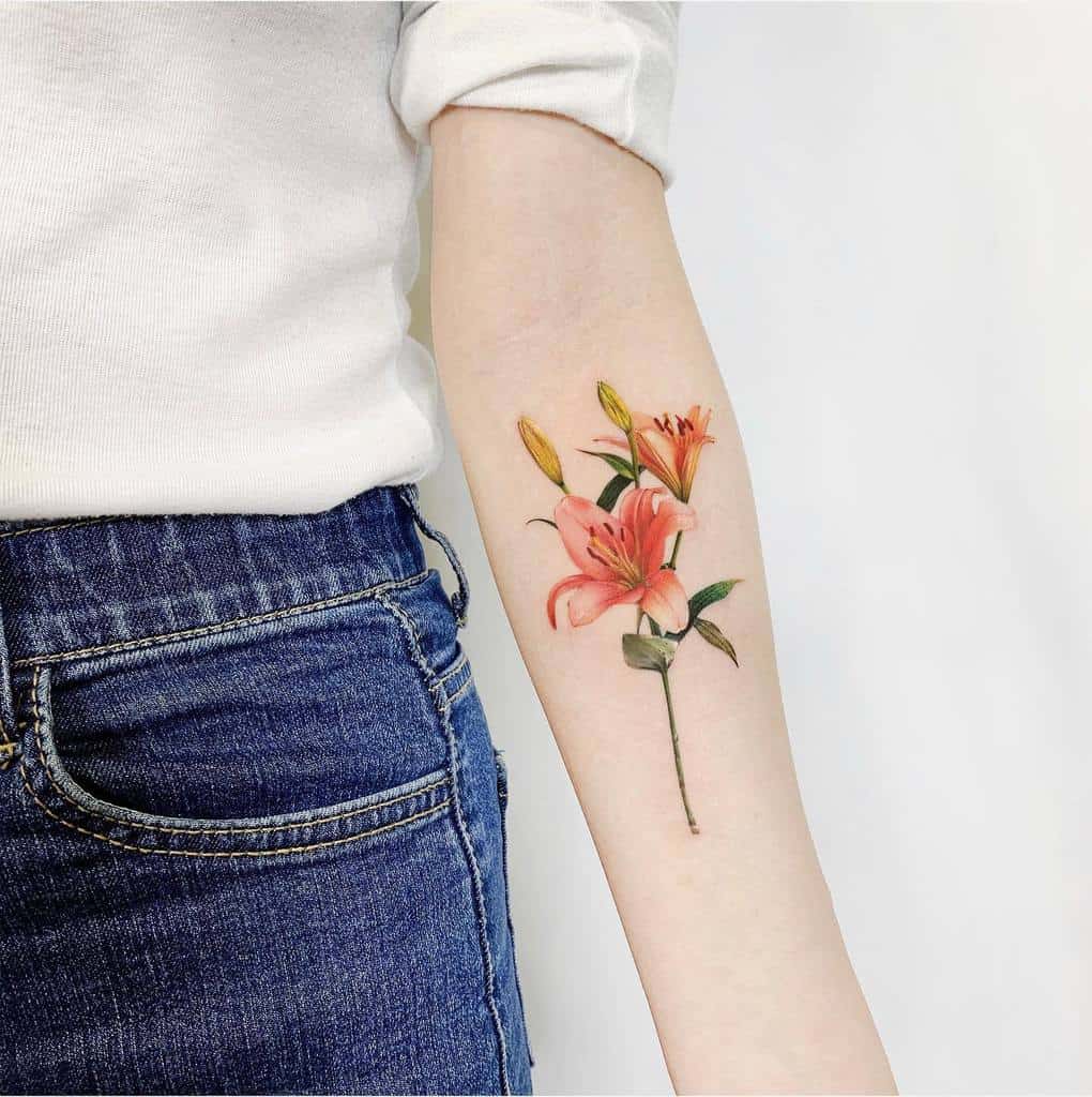 Arm tattoo of pink lilies and buds