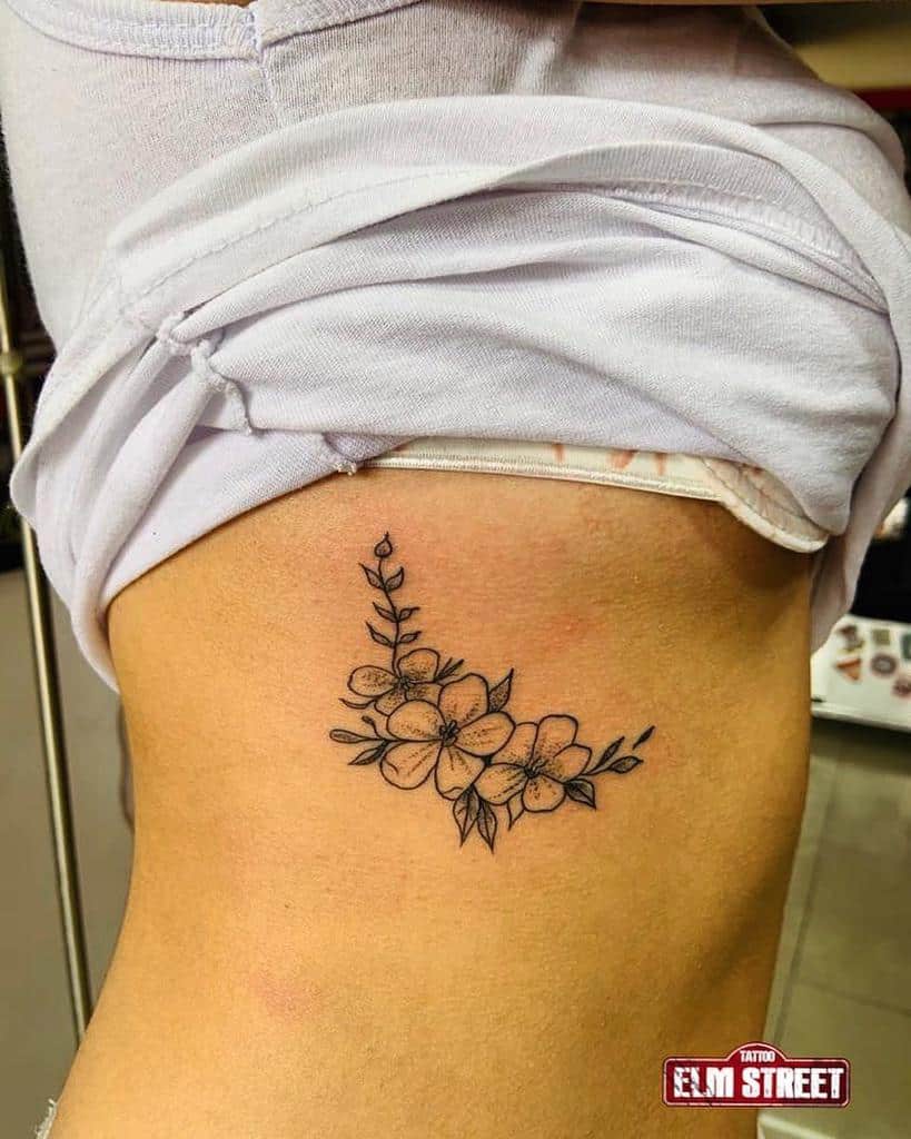 Floral tattoo with intricate leaves on a woman's side