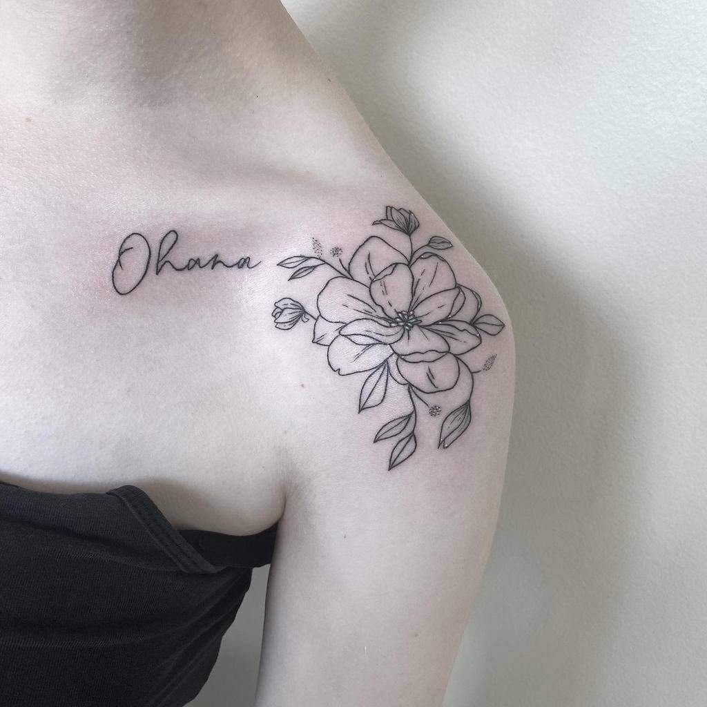 Shoulder tattoo with "Ohana" text and a floral design in black ink
