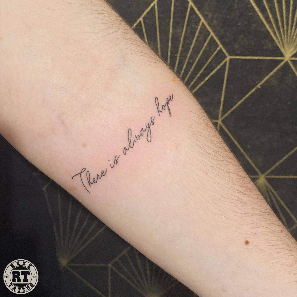 A tattoo on the forearm reads "There is always hope" in cursive script
