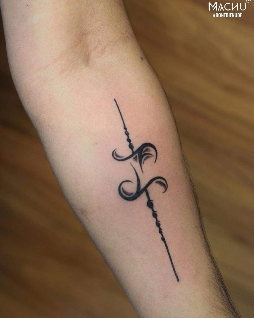 Tattoo on an arm featuring intricate black ink design with curved lines and shading