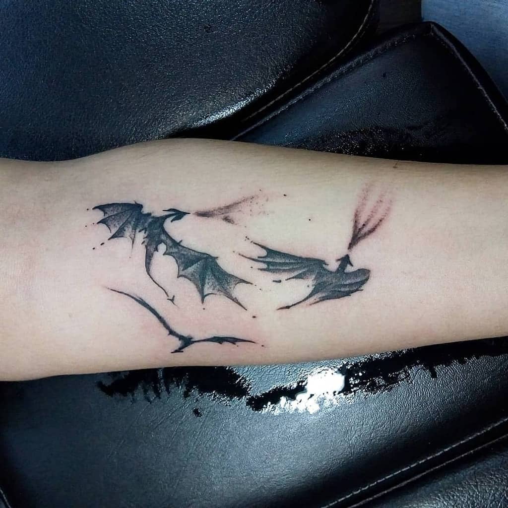 Minimalist dragon tattoo with three delicate dragons in flight, capturing a subtle tribute to Game of Thrones in fine lines