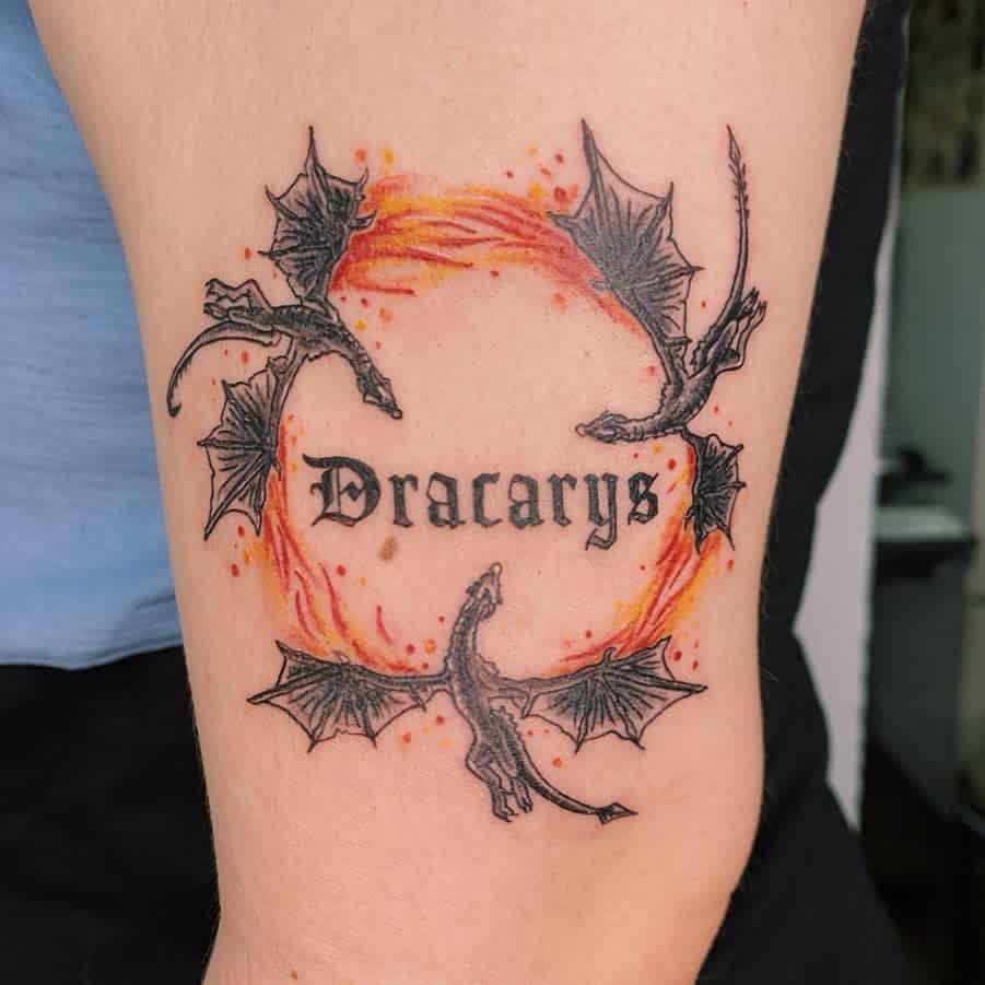 Small Game of Thrones-inspired tattoo featuring three dragons encircling the word 'Dracarys' with flames, symbolizing fire and power
