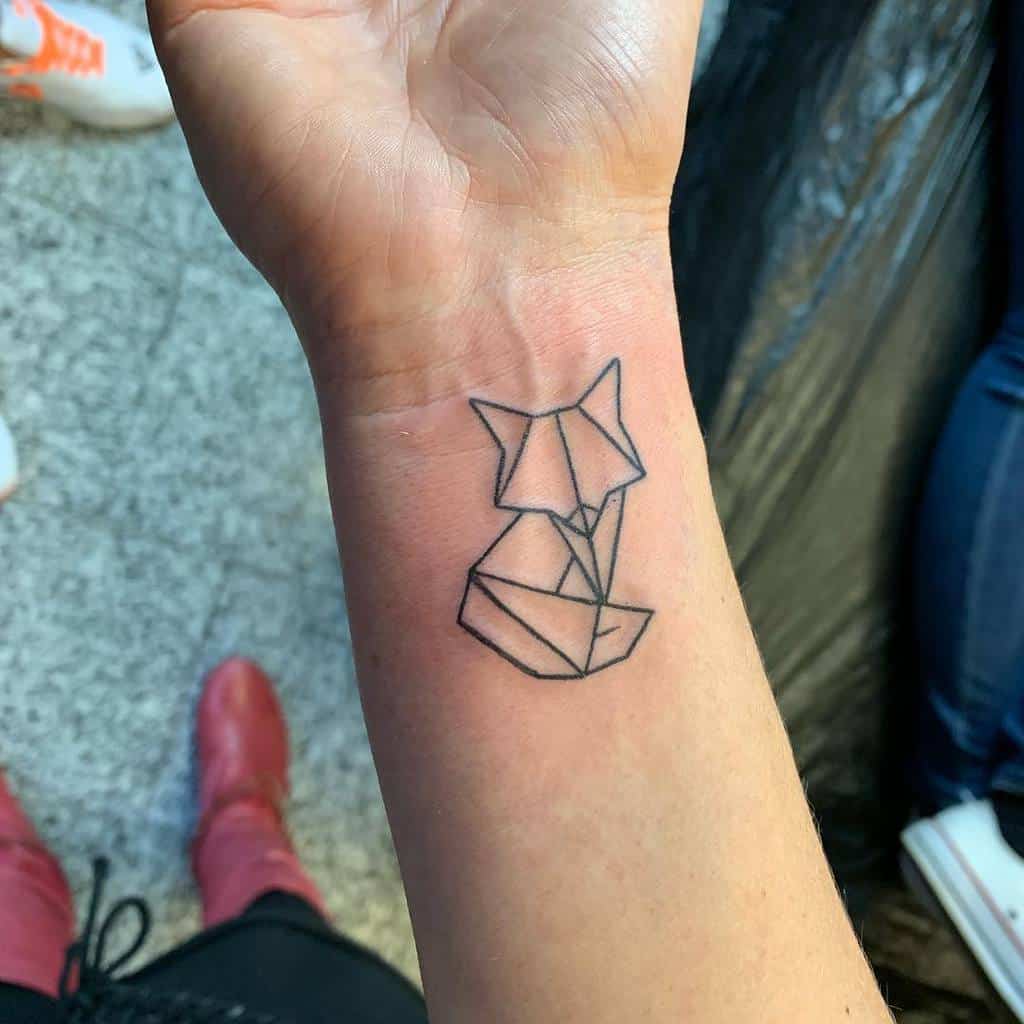 Close-up of a tattoo of a geometric fox on a person's wrist