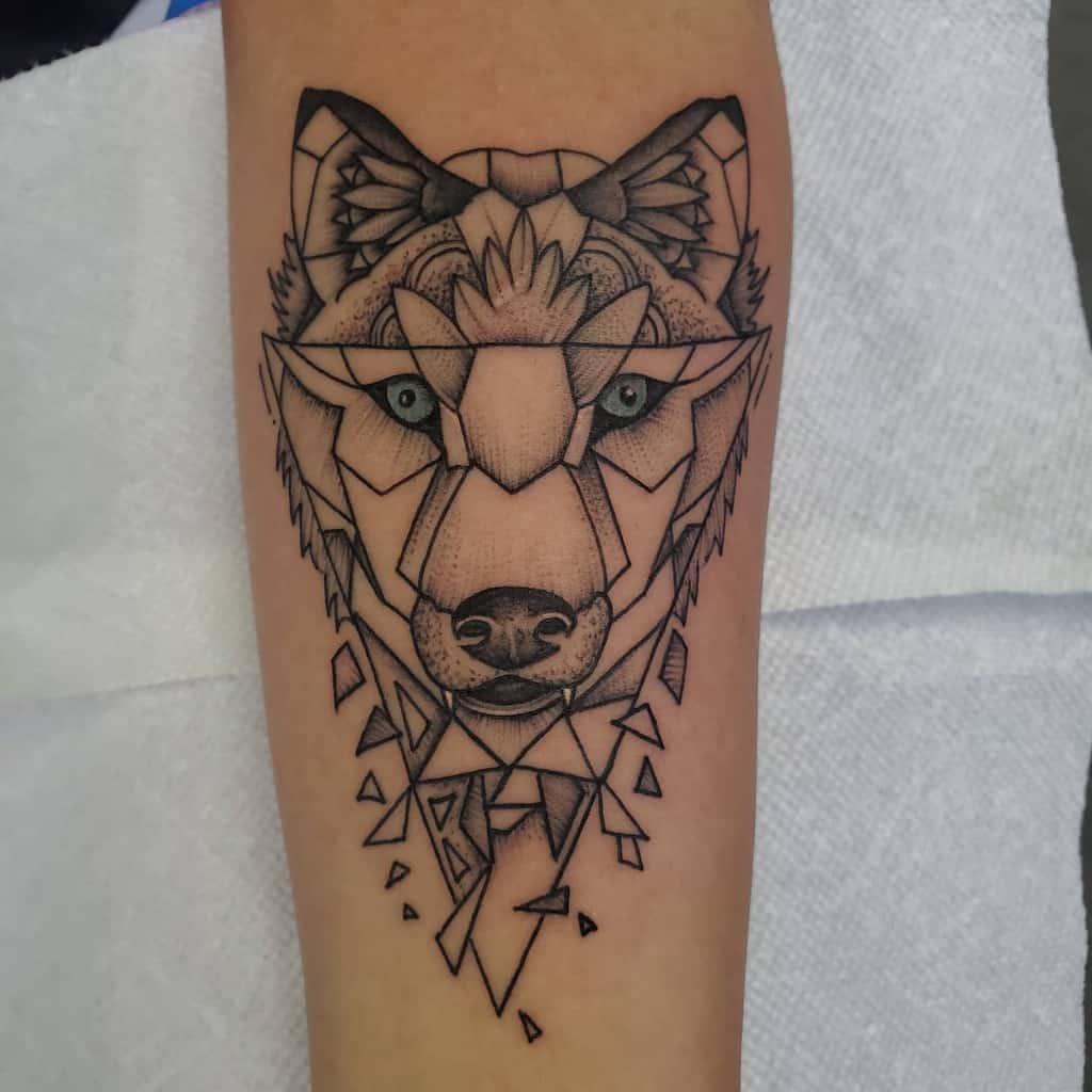 Geometric wolf tattoo design on forearm, featuring intricate lines and sharp angles