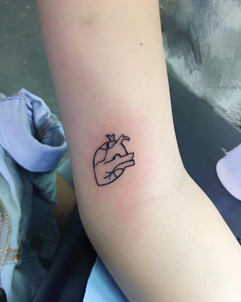 Line art tattoo of an anatomical heart on an arm