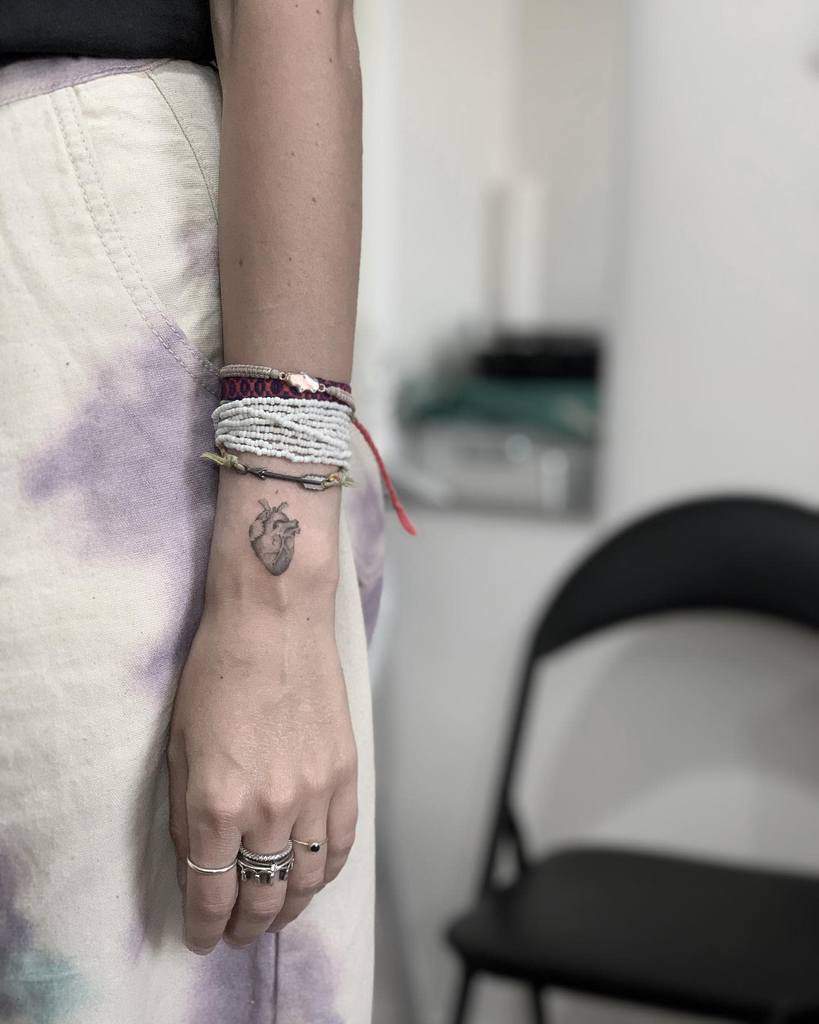 A person with an anatomical heart tattoo on their wrist