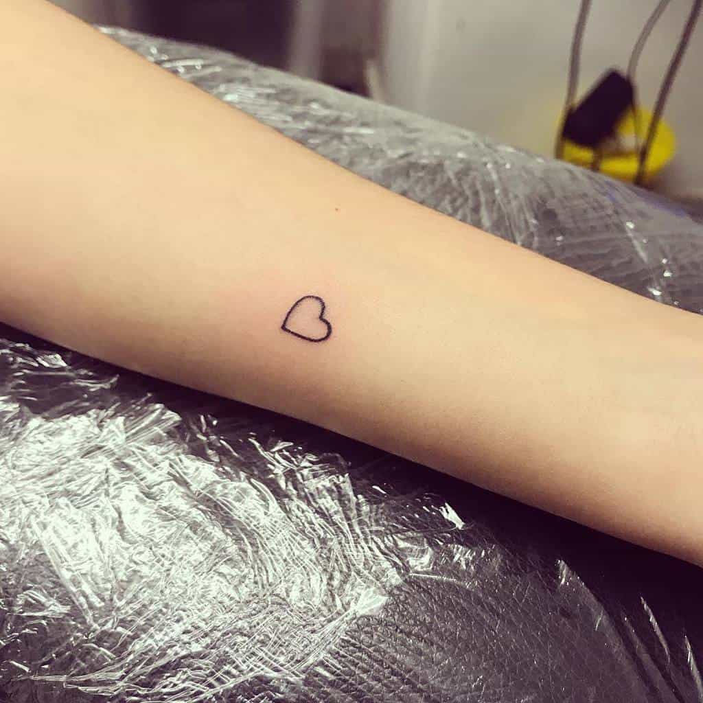 Small heart outline tattoo on a forearm