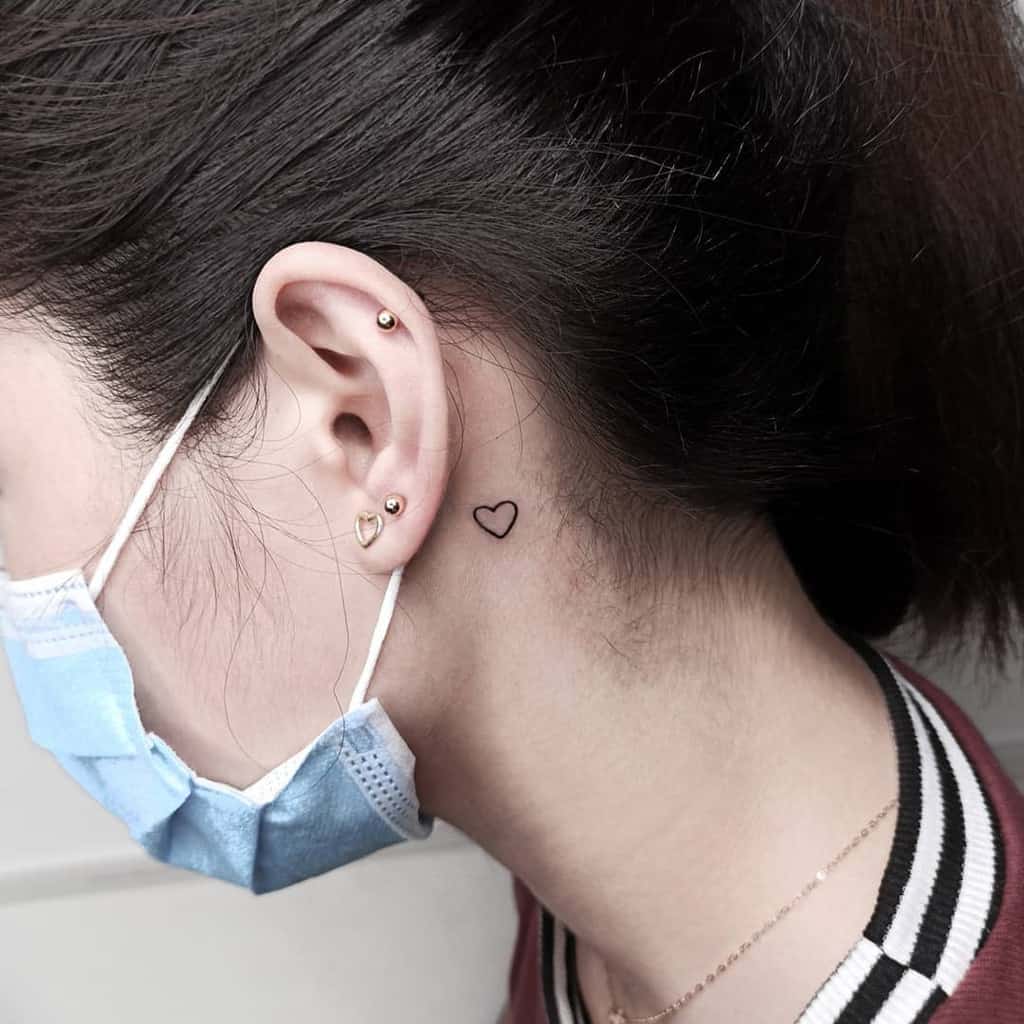 Small heart outline tattoo behind the ear