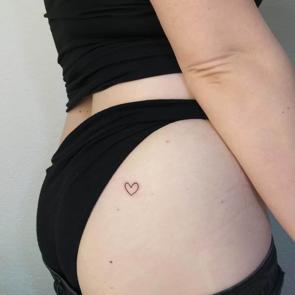 A small heart tattoo on a woman's hip
