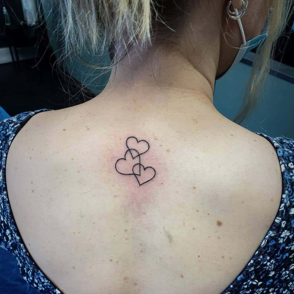 A woman with a tattoo of three interlocking hearts on her upper back