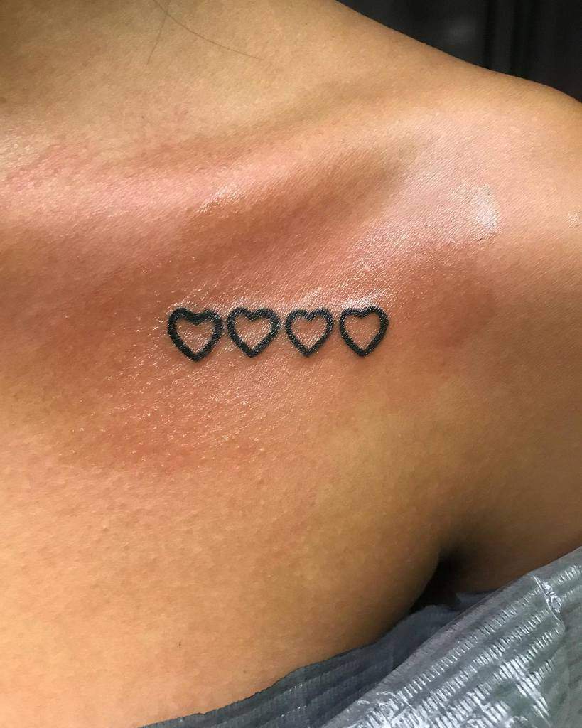 Tattoo of four outlined hearts on a shoulder