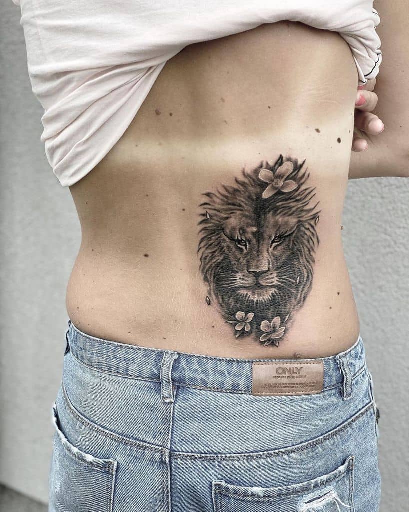 A woman shows a lion tattoo on her side