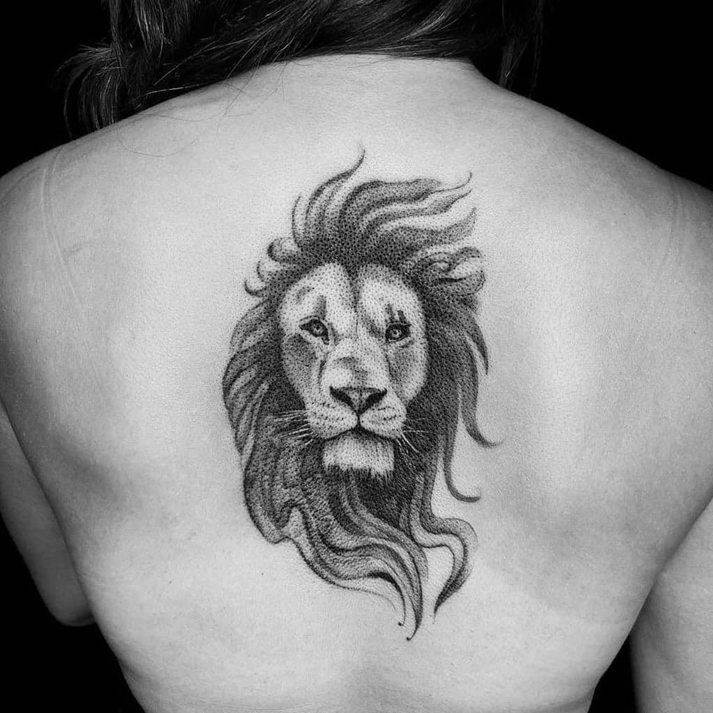 A majestic black and gray lion tattoo graces the upper back, exuding strength and elegance