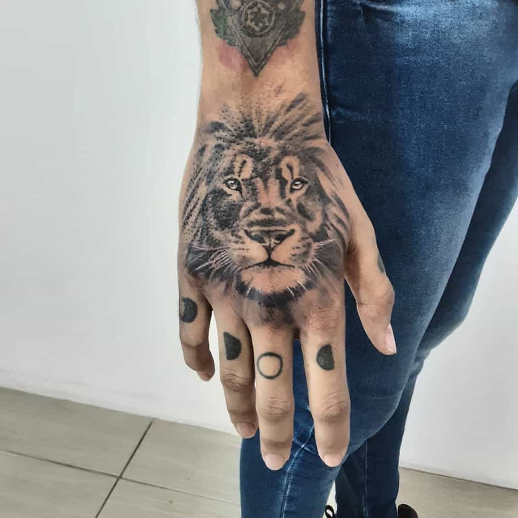 A hand tattoo showcasing a realistic lion's face captures both majesty and strength with intricate detail