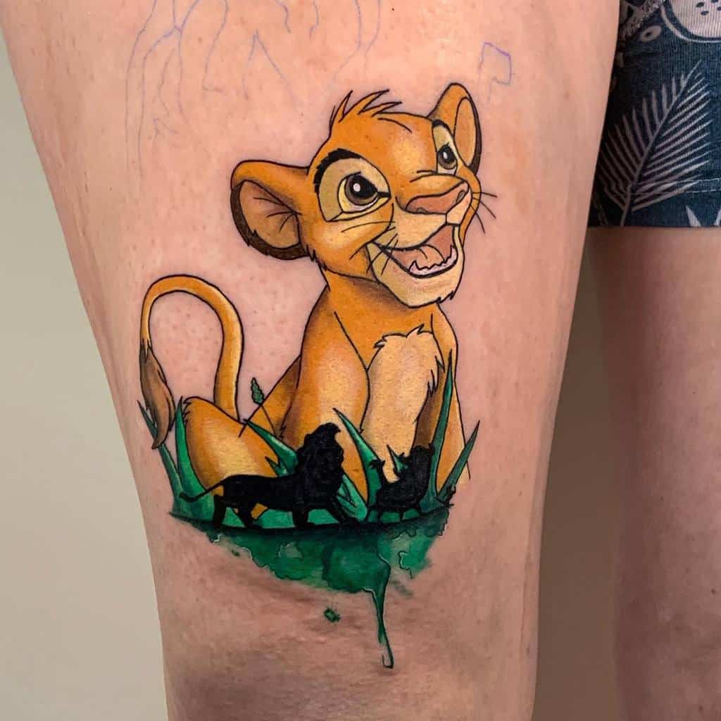 A colorful tattoo of young Simba from The Lion King, with a vibrant background and silhouettes of adult lions, on the thigh