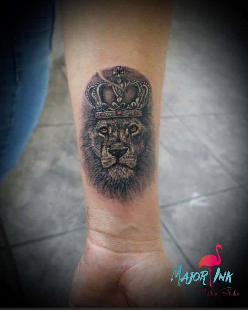 Lion with a crown tattoo on a wrist