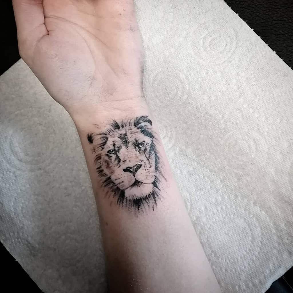 Wrist tattoo of a realistic lion's face on a wrist