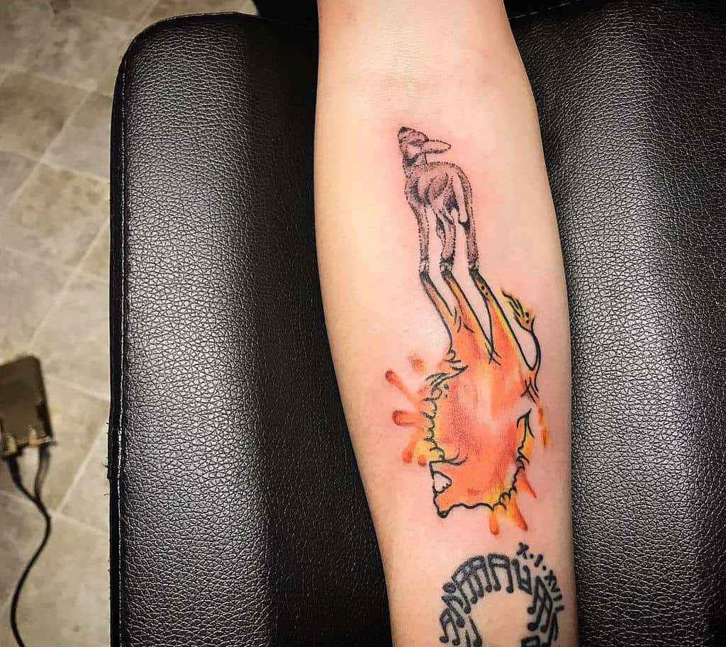 Tattoo of a deer with watercolor effects on the forearm, intertwined with the gentle presence of a lamb