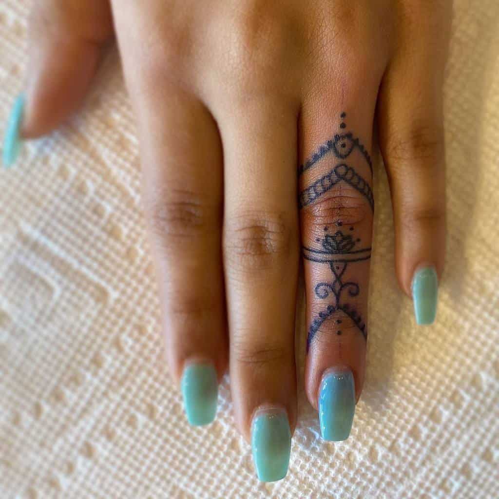 Elegant finger tattoo featuring a delicate mandala-inspired design with intricate lines and dots for a henna-like aesthetic