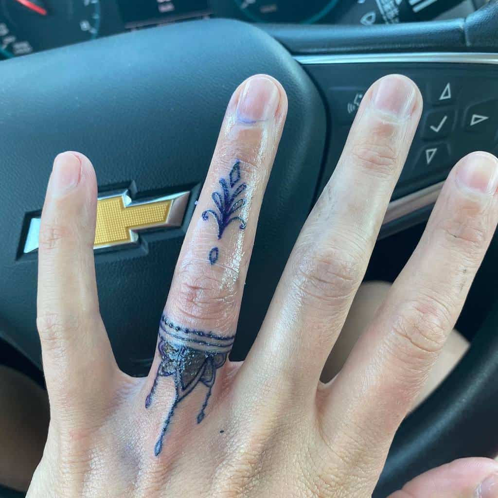 Delicate finger tattoo featuring ornamental designs with floral patterns and decorative lines for a sophisticated look