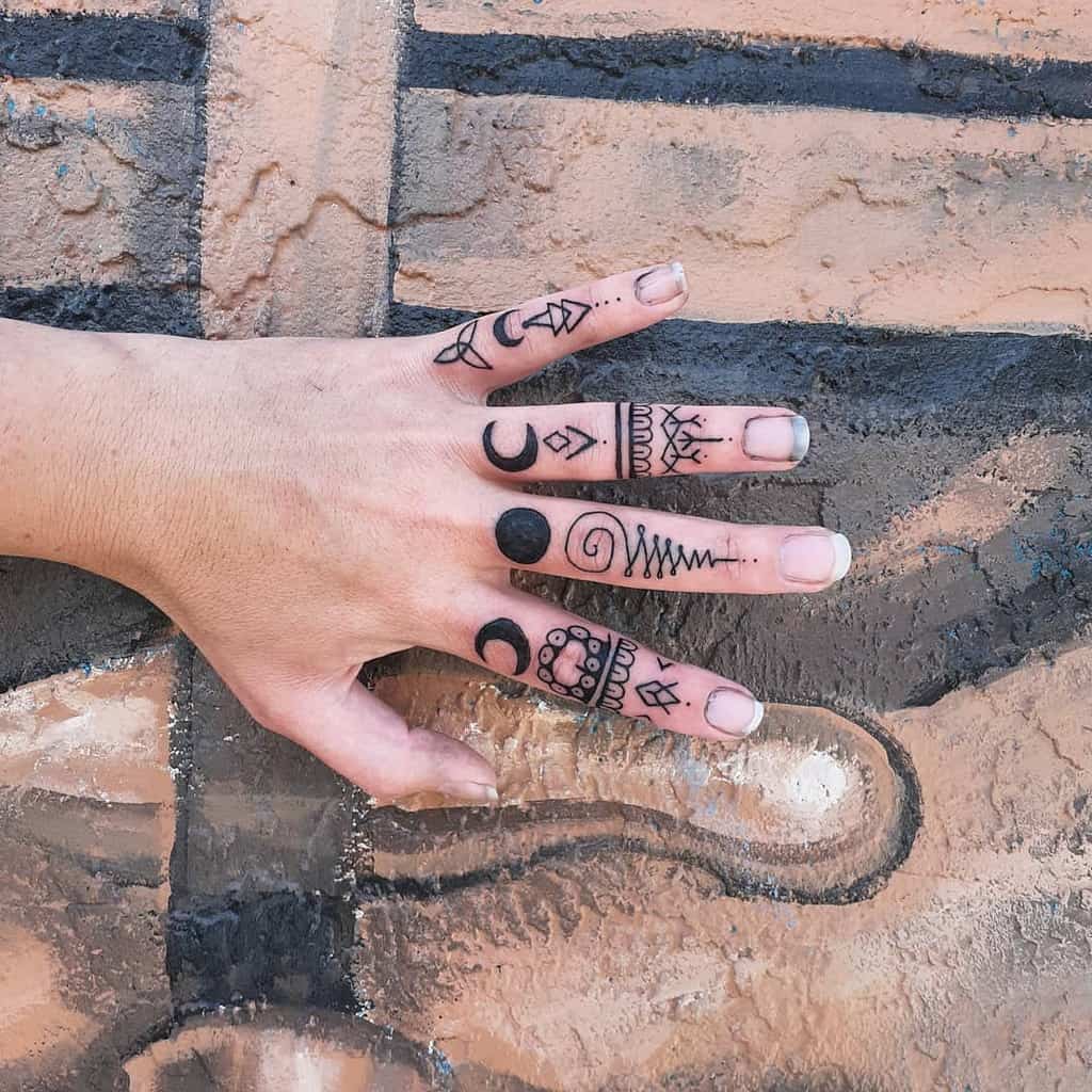 Unique finger tattoos featuring celestial designs, geometric shapes, and ornamental patterns for a mystical and modern look