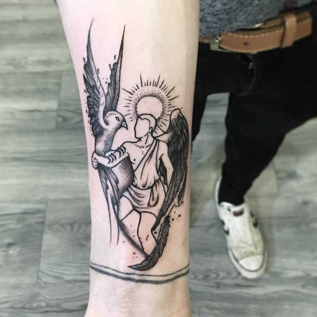 Forearm tattoo of an angel with wings and a halo, standing on an arm with a feather in hand