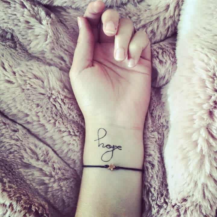 A wrist with a "hope" tattoo
