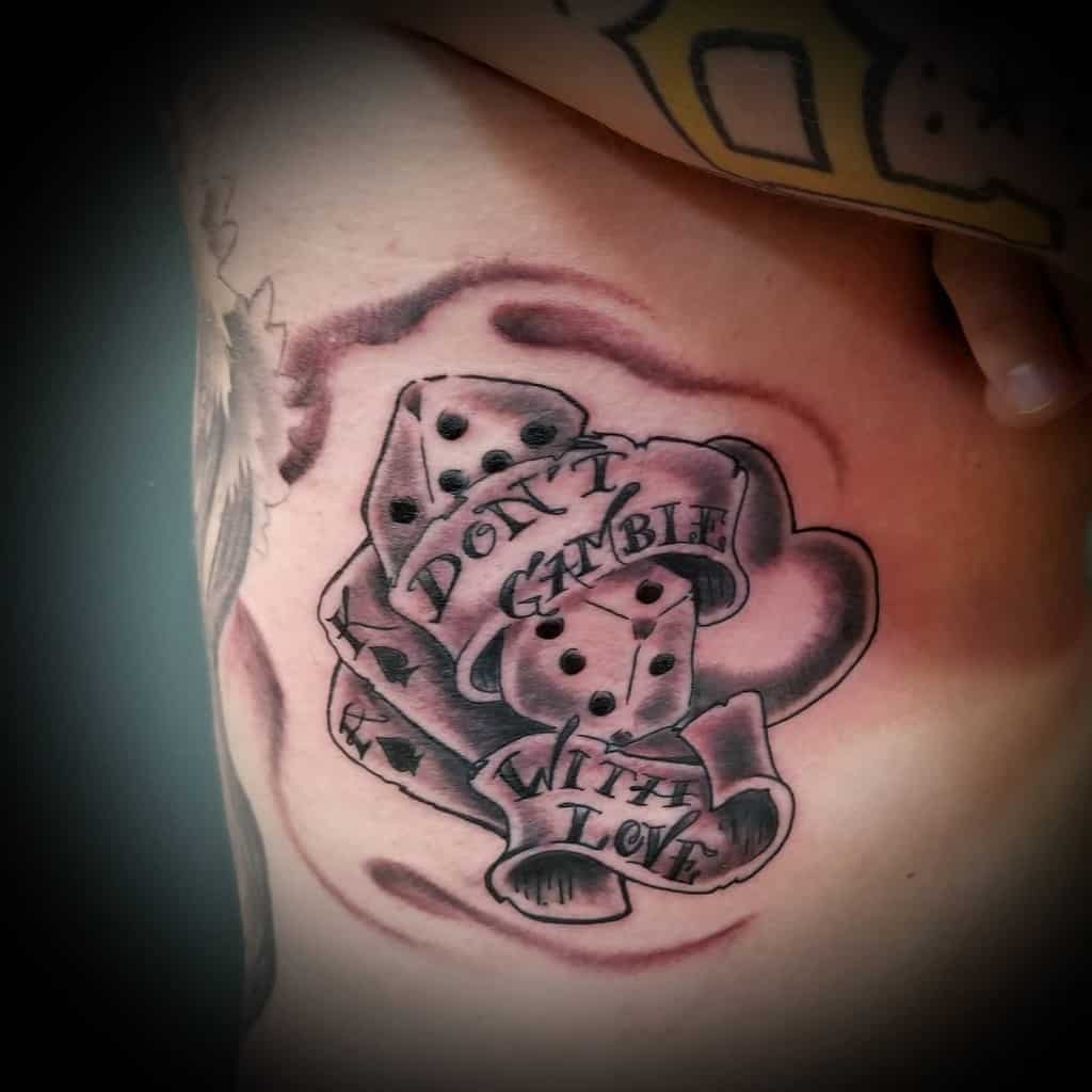 Tattoo of dice with a ribbon that reads "Don't Gamble With Love"