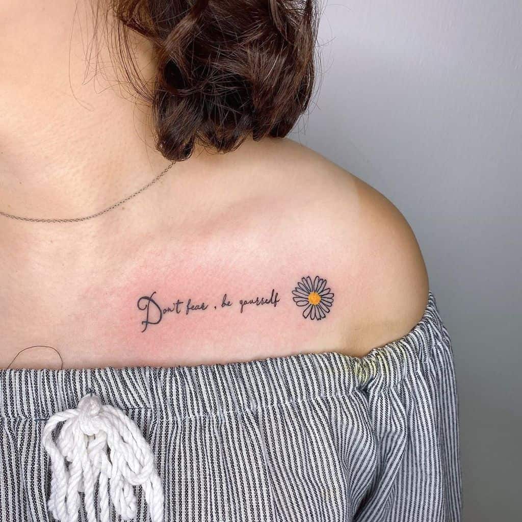 Woman with a shoulder tattoo saying "Don't look, be yourself" and a small daisy design