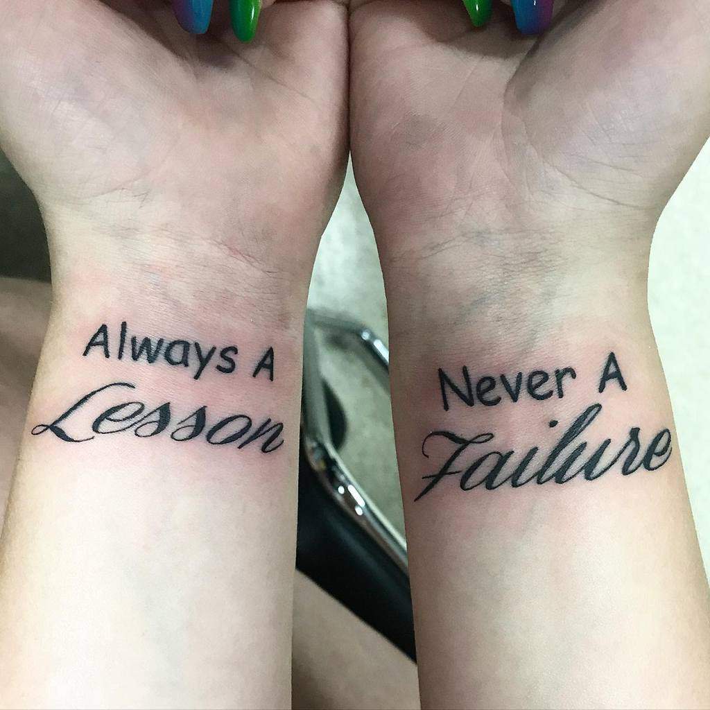 Two wrists with tattoos: "Always a Lesson" on the left and "Never a Failure" on the right