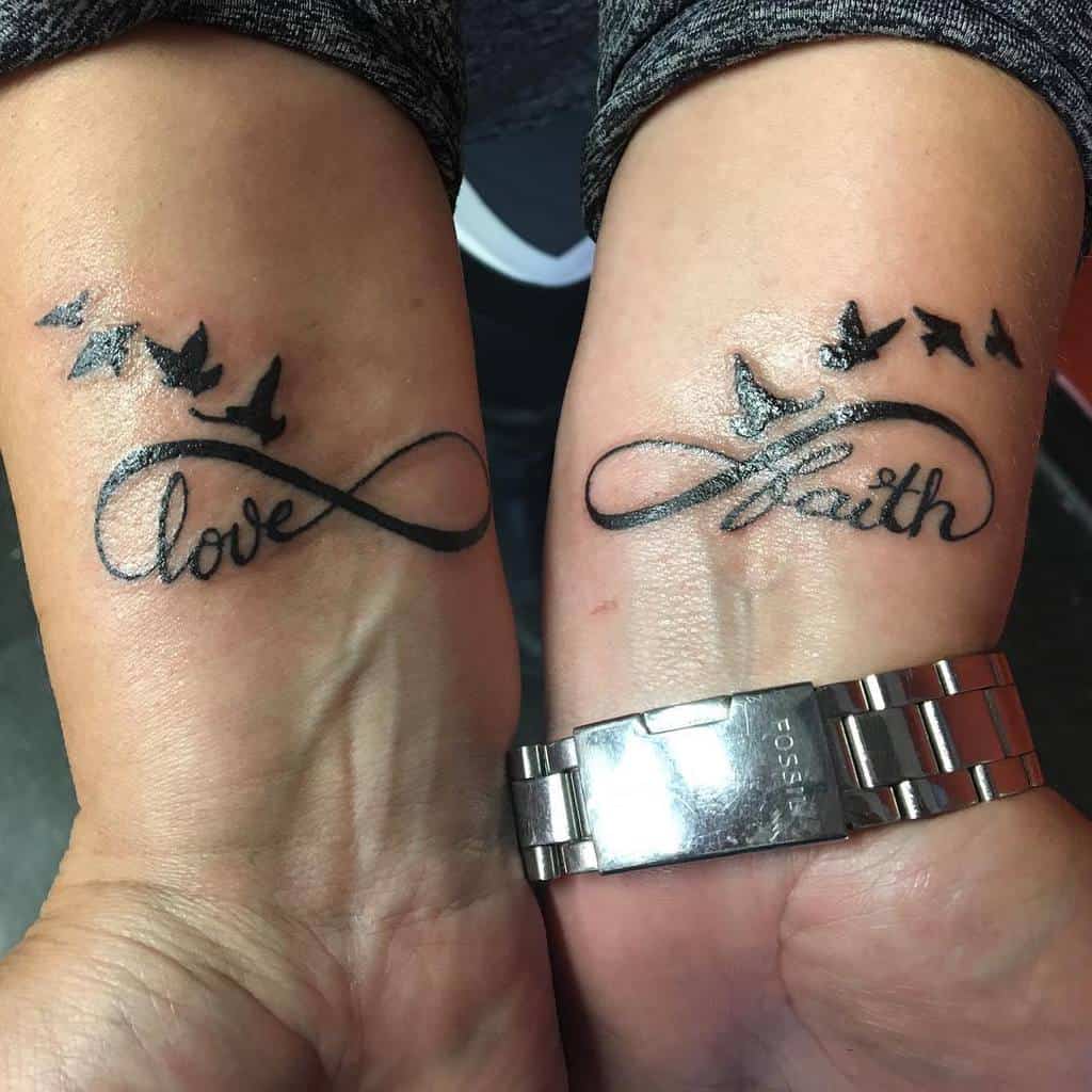 Two wrists with infinity tattoos, one reading "love" and the other "faith," accompanied by bird silhouettes