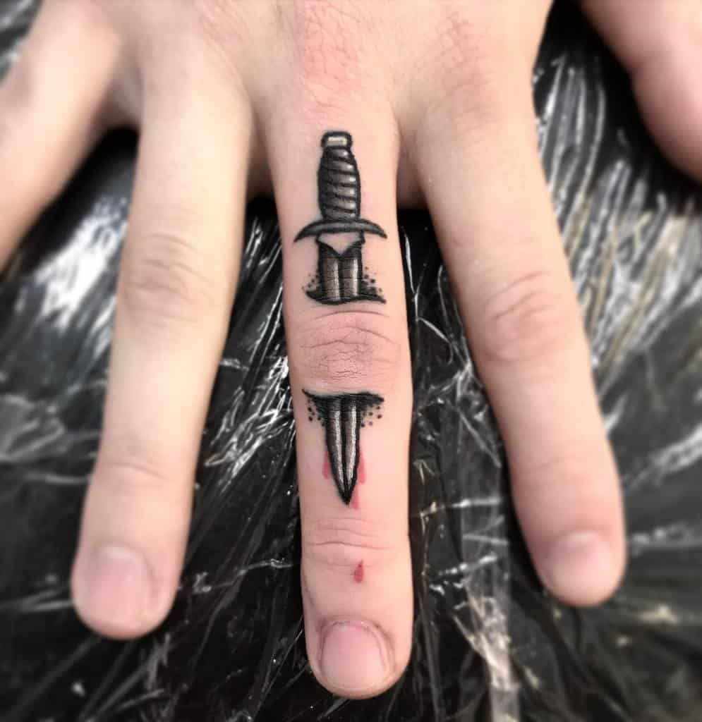 Tattoo of a dagger on a middle finger with realistic shading and design details
