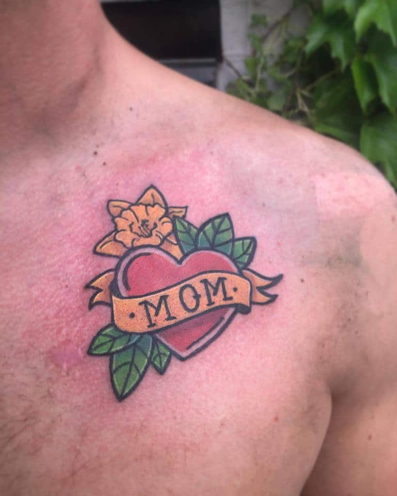 A tattoo of a heart with "MOM," surrounded by leaves and a flower, beautifully inked