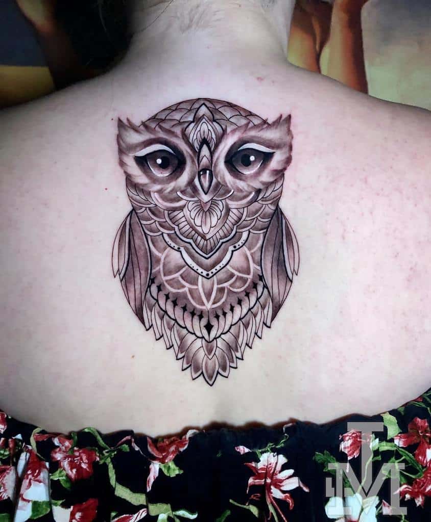 An intricately designed owl graces the upper back, showcasing its ornate features in stunning detail