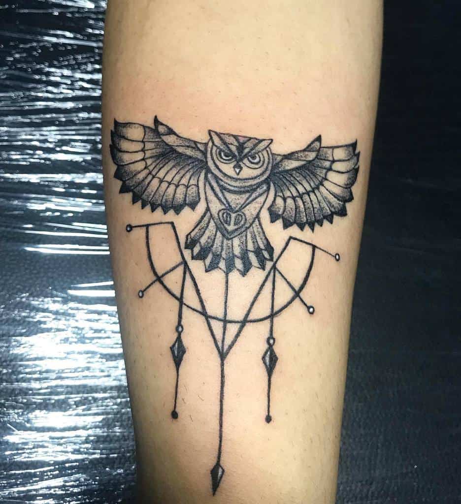 A stunning geometric owl tattoo with majestic spread wings graces the forearm, capturing the essence of both wisdom and art