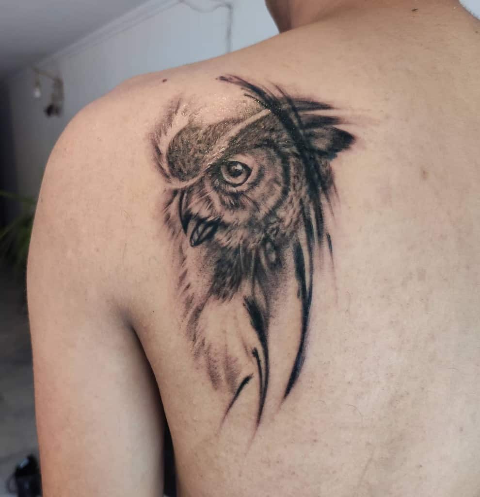 A stunningly detailed tattoo of a wise owl takes flight across the back