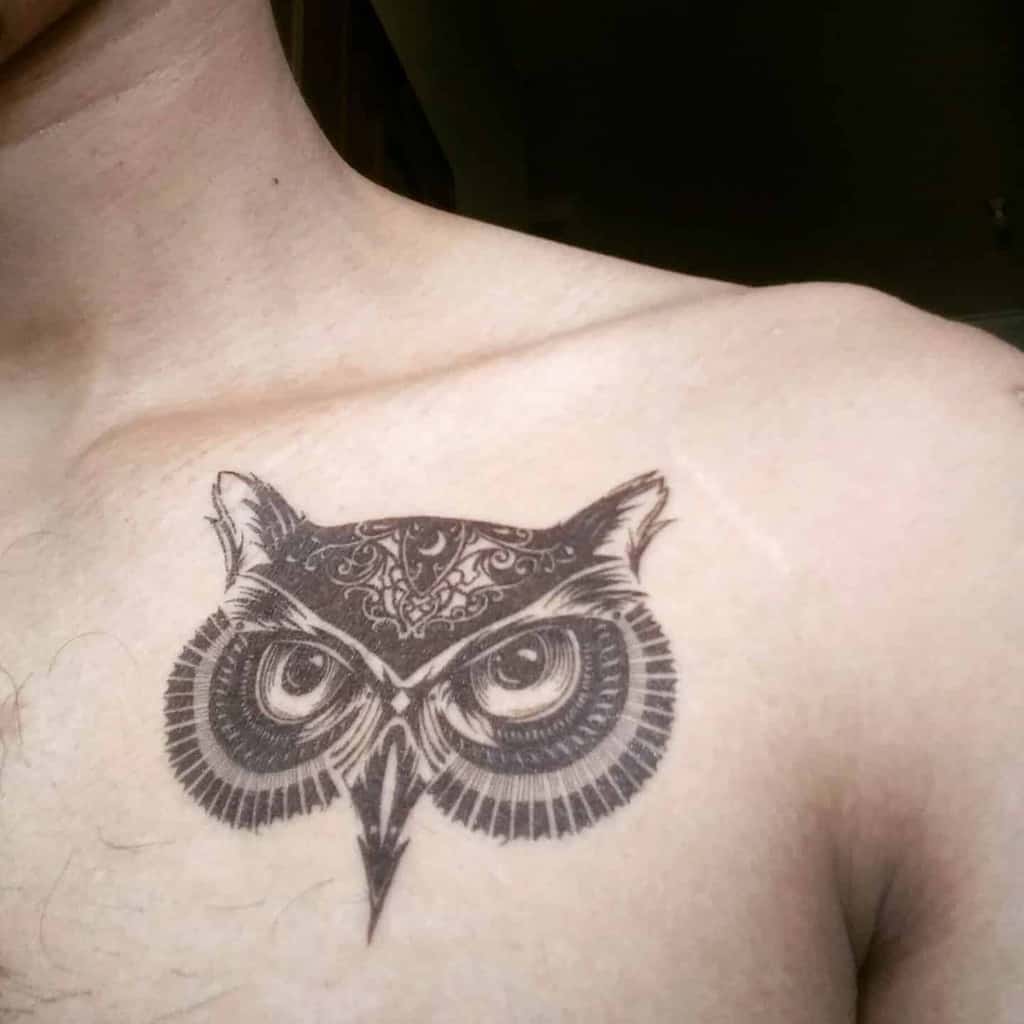 An owl tattoo, beautifully detailed with intricate patterns, adorns the person's chest