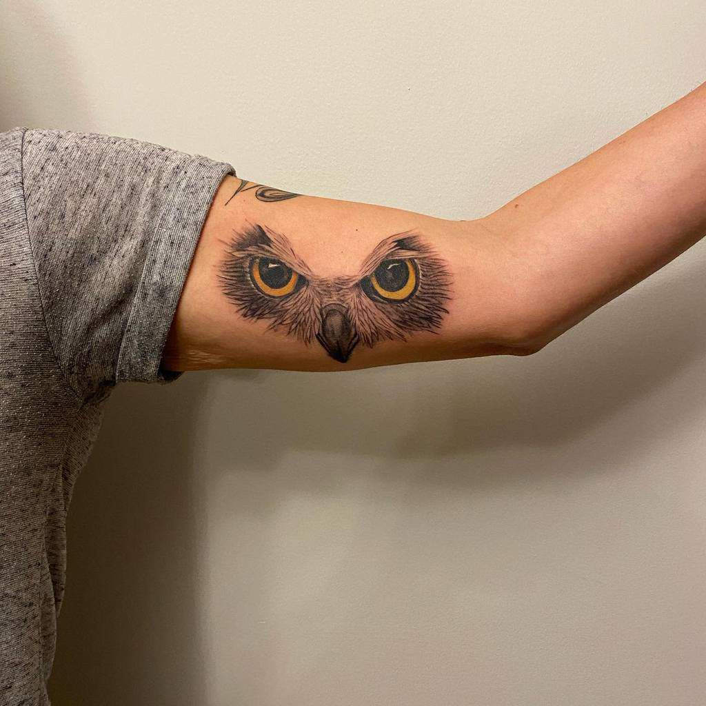 An owl tattoo on the inner bicep of an arm
