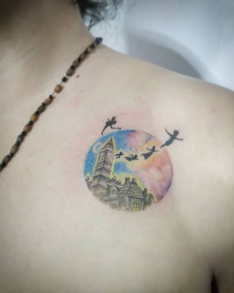 Peter Pan, Wendy, and brothers flying over London rooftops in a dreamy, colorful tattoo with circle frame