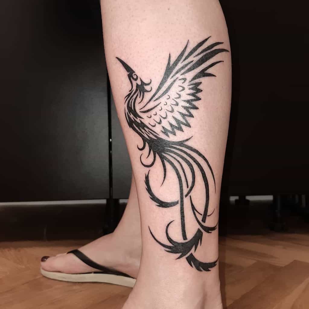 Phoenix tattoo in black ink on a calf