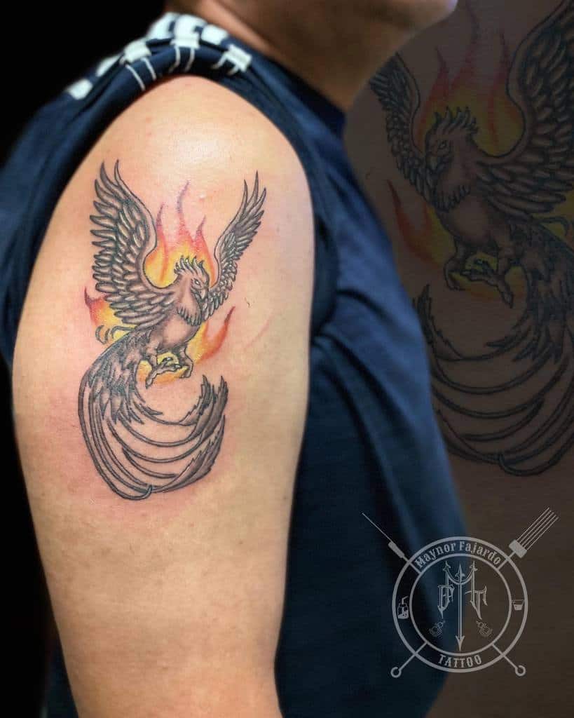 A phoenix tattoo with flames on a man's upper arm
