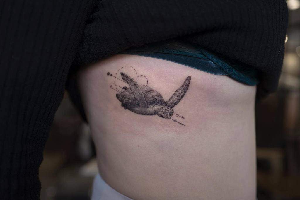 Tattoo of a sea turtle on a woman's side