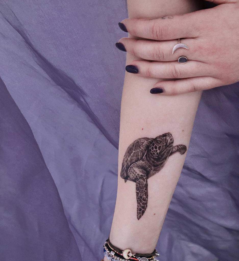 Arm tattoo of a realistic sea turtle