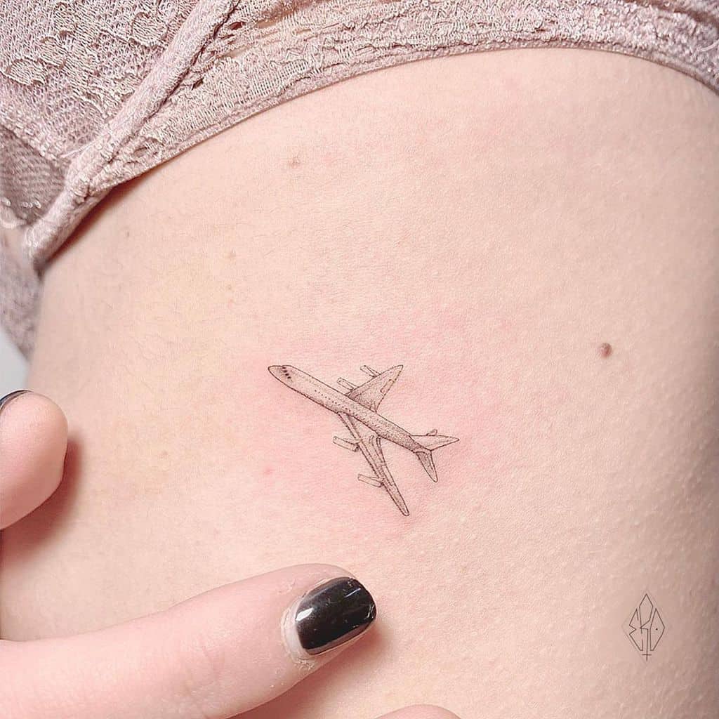 A small airplane tattoo on a woman’s side