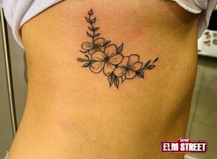 Simple floral tattoo with leaves on skin, featuring delicate line art