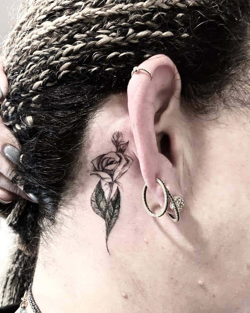 Close-up of a rose tattoo behind an ear