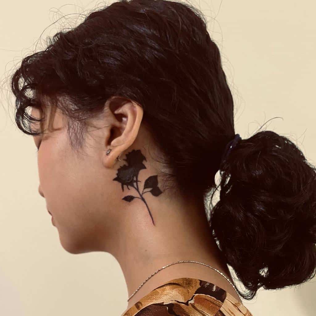 Woman with a black rose tattoo on her neck