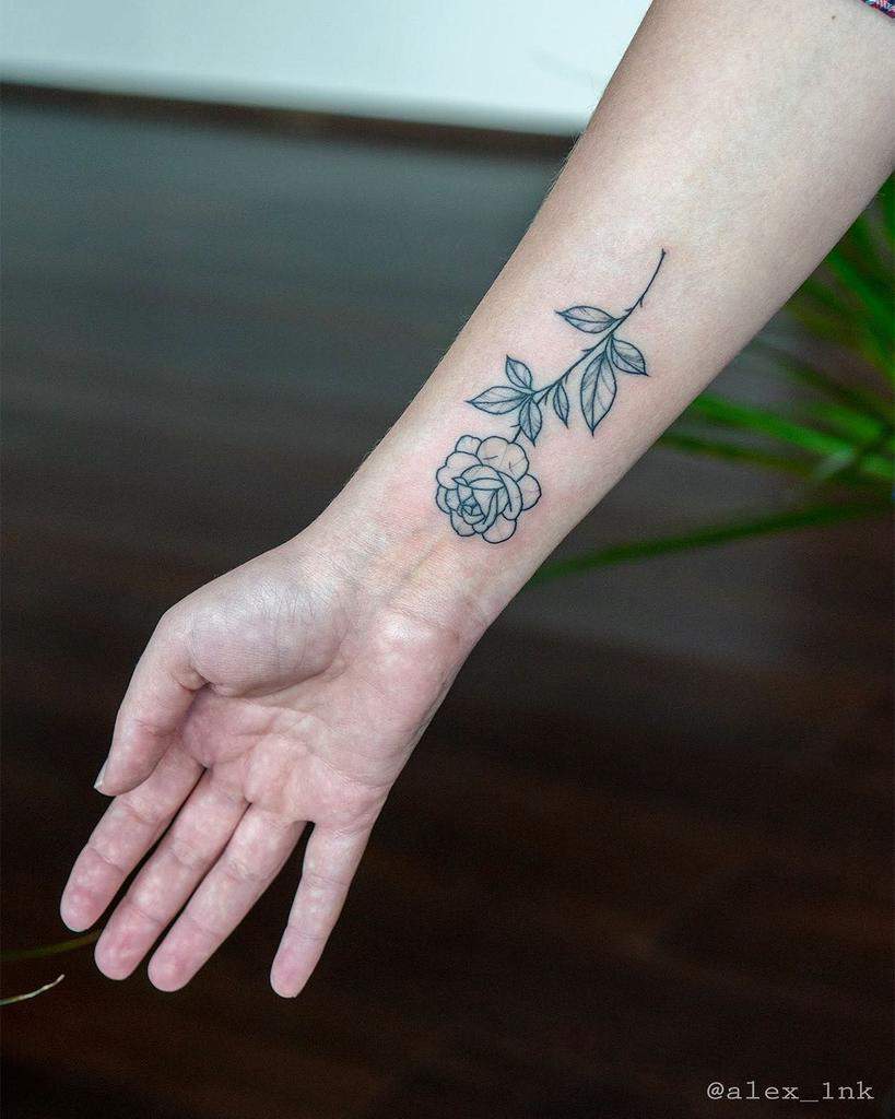 Wrist tattoo of a rose with leaves