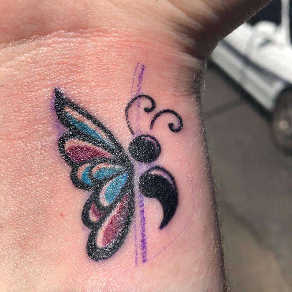 Colorful semicolon butterfly tattoo representing strength and renewal, with vibrant hues and delicate, flowing lines